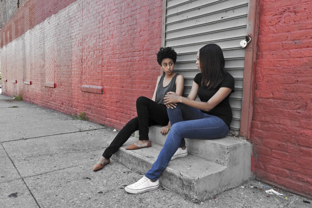 Two girls sitting on the stairs in a low income neighborhood.